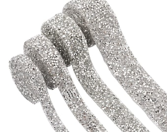 May include: Four rolls of silver rhinestone trim, each with a different width. The trim is made of small, sparkling rhinestones.