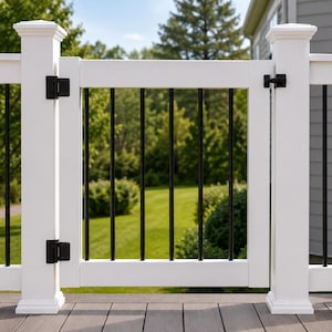 May include: A white deck gate featuring vertical black metal balusters, secured to white posts with black hinges and a black latch. The gate is positioned between two white railing sections, creating a barrier on a wooden deck surface.
