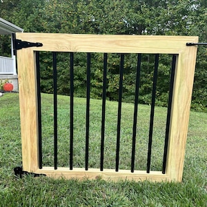 May include: A wooden gate with black metal bars. The gate is closed and has a black metal latch.
