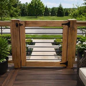 May include: A wooden gate featuring a natural light brown finish with horizontal black metal bars. The gate is secured with black metal hinges and a latch, integrated into a matching wooden railing system on a dark brown deck surface.