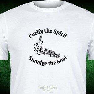 May include: White t-shirt with black text that reads "Purify the Spirit Smudge the Soul" and a black and white illustration of a smudge stick with smoke rising from it. The text "Tribal Vibes World" is printed in the bottom center of the shirt.