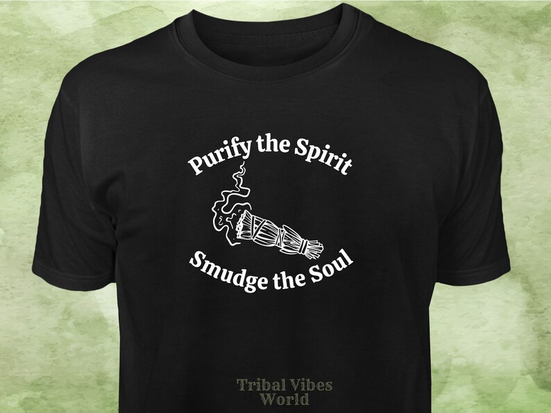 May include: Black t-shirt with white text that reads "Purify the Spirit" and "Smudge the Soul" with a white illustration of a smudge stick and smoke. The text "Tribal Vibes World" is printed in white at the bottom of the shirt.