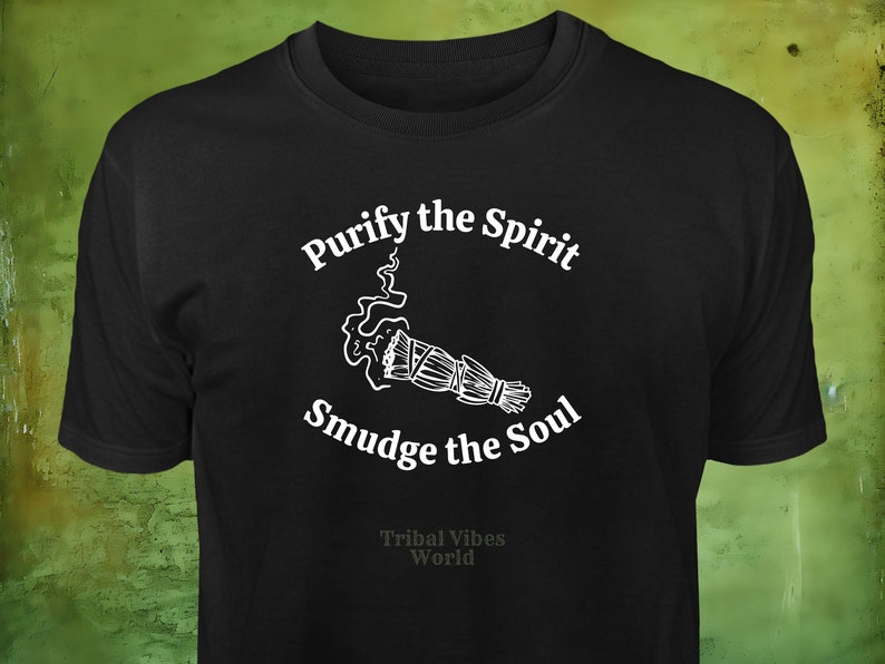 May include: Black t-shirt with white text that reads "Purify the Spirit Smudge the Soul" and a white illustration of a smudge stick with smoke. The text "Tribal Vibes World" is also printed in white at the bottom of the shirt.