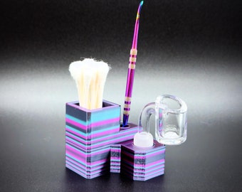 May include: A multi-colored, striped holder with a brush, a purple and gold tool, and a clear glass component. The text "Electric Opal" is displayed at the bottom of the image. The holder is designed to organize and store accessories.