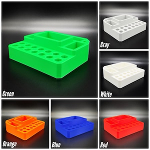 May include: A multi-compartment desk organizer in various colors, including green, gray, white, orange, blue, and red. The organizer features multiple sections and a series of small circular holes, ideal for storing pens, pencils, and other office supplies.