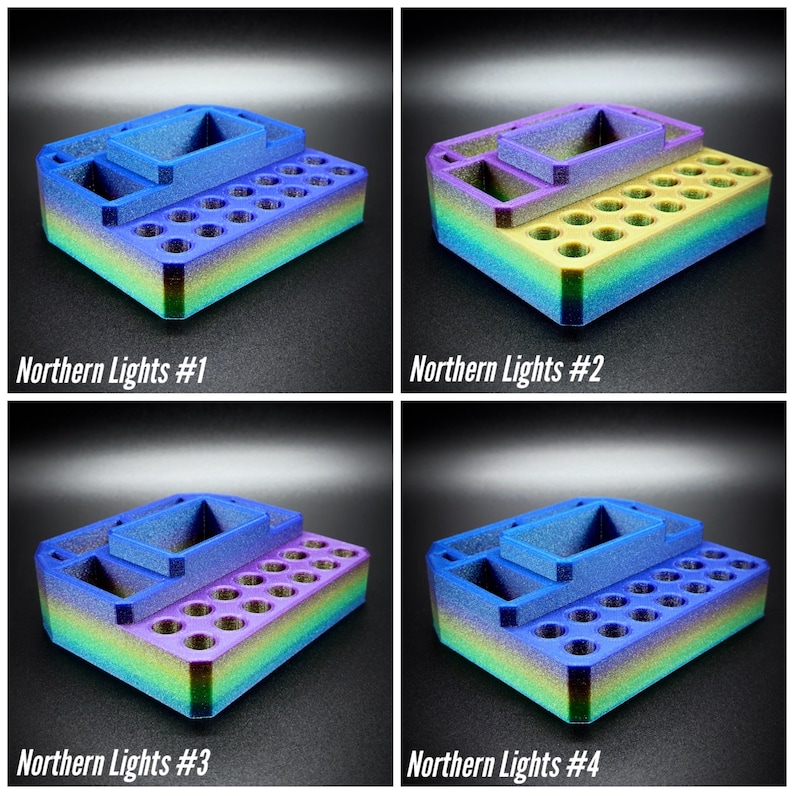 May include: Four multi-colored 3D-printed organizers with the text "Northern Lights #1, #2, #3, #4". Each organizer has a rectangular base with multiple holes and a raised section with two compartments. The colors transition from blue to green to yellow to purple.