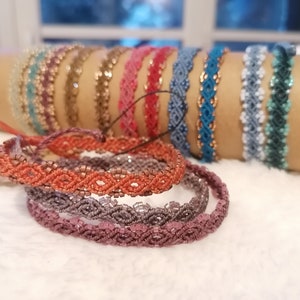 Puede incluir: Un conjunto de pulseras de amistad coloridas con intrincados patrones tejidos. Las pulseras están hechas con hilos y cuentas de diferentes colores, creando un look único y elegante.