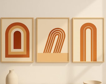 以下が含まれることがあります： オレンジとクリーム色の抽象的なアーチデザインの3つの額入りアートプリント。プリントはクリーム色の壁に展示されています。白い花瓶と小さなボウルがクリーム色の表面にあります。