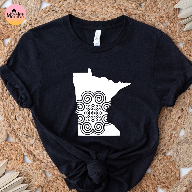 May include: Black t-shirt with a white outline of the state of Minnesota with a white geometric design inside.