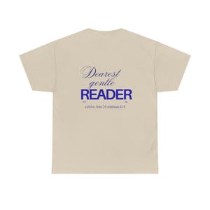 May include: A beige t-shirt with the words "Dearest gentle READER" in blue script and block letters. Below the text is the phrase "with love, from 2 Corinthians 4:18". The shirt is made of a soft material.