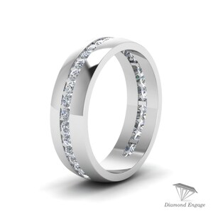 May include: A polished, silver-toned ring with a channel setting. The ring features two parallel rows of small, clear gemstones. The design is simple and elegant, with a high-shine finish. The ring is set against a white background.