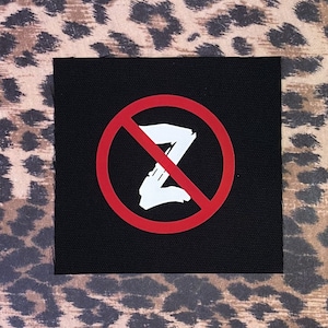 May include: A black patch with a red circle and a white letter Z with a diagonal line through it. The text "No Z" is implied.