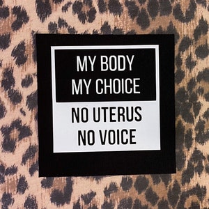 Op de afbeelding: Zwarte en witte vierkante patch met de tekst "My Body My Choice" en "No Uterus No Voice" op een roze en bruine luipaardprint achtergrond.