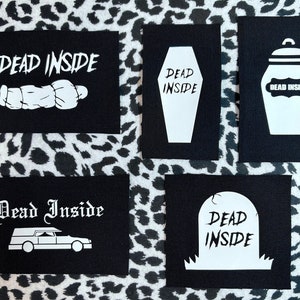 May include: Five black fabric patches with white text and images. The patches feature the phrase "Dead Inside" with various images including a coffin, a jar, a tombstone, a hearse, and a sleeping figure.