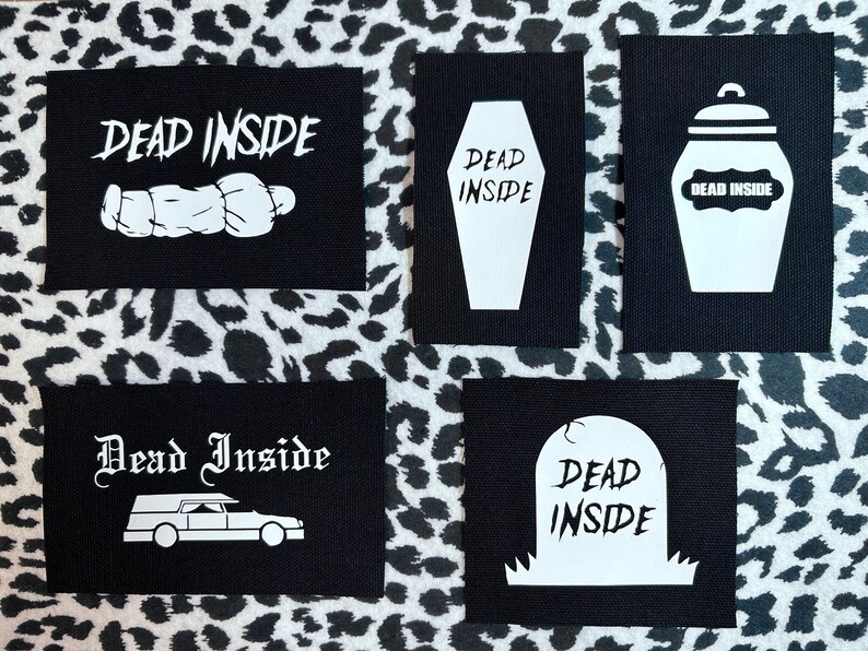 May include: Five black fabric patches with white text and images. The patches feature the phrase "Dead Inside" with various images including a coffin, a jar, a tombstone, a hearse, and a sleeping figure.