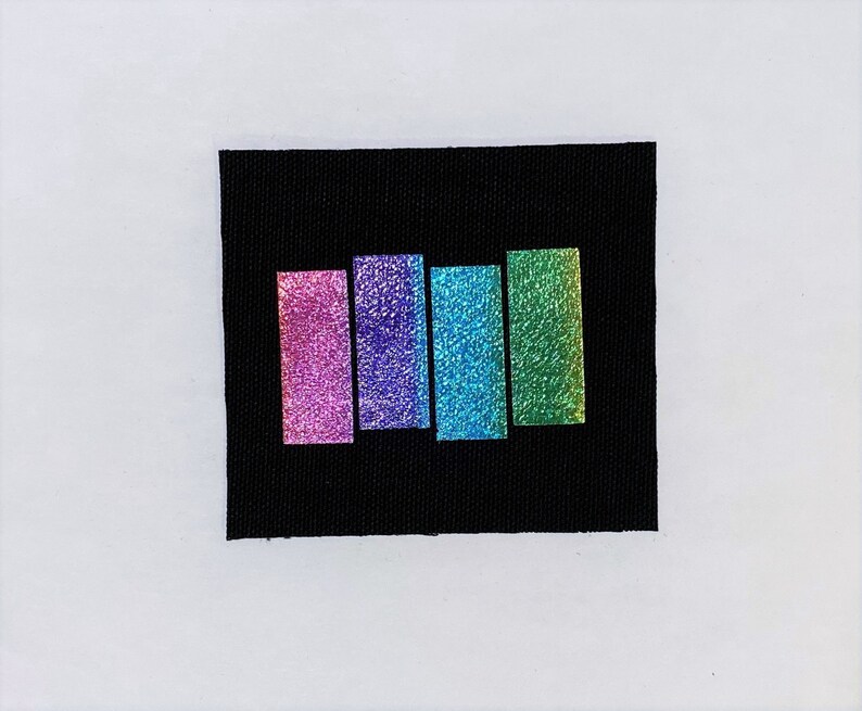 May include: Five iridescent fabric swatches in shades of pink, purple, blue, green, and teal. The swatches are arranged vertically on a black background.