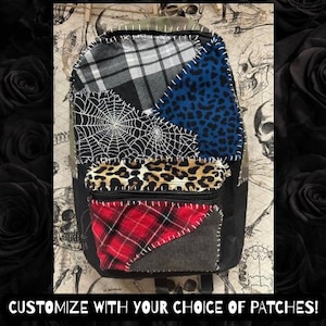 May include: Black backpack with a patchwork design featuring plaid, leopard print, and a spiderweb. The backpack has a front zippered pocket and is accented with white stitching. The text "CUSTOMIZE WITH YOUR CHOICE OF PATCHES!" is at the bottom.