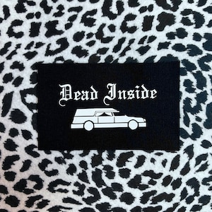 May include: Black patch with white text that reads "Dead Inside" and a white silhouette of a hearse.