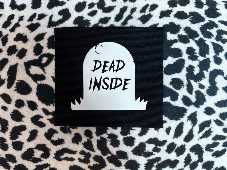 May include: Black fabric patch with a white tombstone graphic that says "DEAD INSIDE".