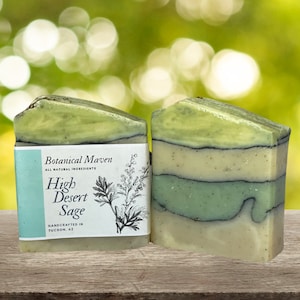 May include: Two bars of handmade soap with a green, white, and black layered design. The soap is labeled "Botanical Maven High Desert Sage Handmade in Tucson, AZ"