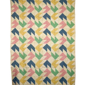 May include: A handmade quilt with a repeating geometric pattern. The design features alternating rows of colorful arrow-like shapes in blue, pink, green, and yellow against a cream background. The quilt is likely made of cotton and is suitable for a bed or as a decorative throw.