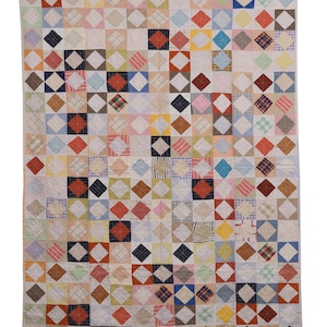 May include: A rectangular quilt featuring a grid of diamond-shaped fabric patches in various colours and patterns, including red, blue, yellow, green, and plaid designs. The quilt is constructed with visible stitching throughout the surface.
