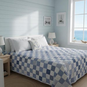 May include: A bedroom scene featuring a bed with a blue and white checkered quilt. The room has light blue walls, a window with an ocean view, and nautical-themed decor, including an anchor pillow and framed sailboat art.