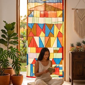 May include: A rectangular curtain featuring a vibrant, multi-coloured geometric patchwork design with various shapes in shades of red, blue, yellow, and green. The curtain is suspended from a wooden rod by fabric tabs at the top edge.