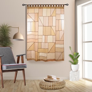 Może przedstawiać: Beżowo-brązowa zasłona z geometrycznym wzorem, zawieszona na ozdobnym drążku. Zasłona ma wzór patchworkowy z prostokątów i trójkątów w różnych odcieniach beżu i brązu. Pokój zawiera krzesło, stolik pomocniczy i roślinę.