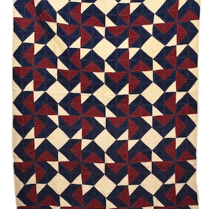 Könnte beinhalten: Eine handgefertigte Steppdecke mit einem sich wiederholenden geometrischen Muster. Das Design zeigt abwechselnde Blöcke in Creme, Marineblau und Burgunderrot. Die Steppdecke ist rechteckig und hat eine genähte Textur. Der Text "VL1113" ist unten sichtbar.