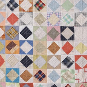 Peut inclure: Un quilt en patchwork composé d'une grille répétitive de blocs de tissu carrés, chacun contenant une forme de losange centrée. L'ouvrage présente divers motifs textiles, notamment des carreaux, des rayures et des couleurs unies dans des tons de bleu, rouge, orange, jaune, vert et blanc, assemblés par des coutures en fil blanc visibles.