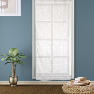 May include: White sheer window curtain with a geometric pattern, hanging in a white window frame. The curtain is semi-transparent, allowing light to filter through. The room has a blue wall, a potted plant, and a woven ottoman.