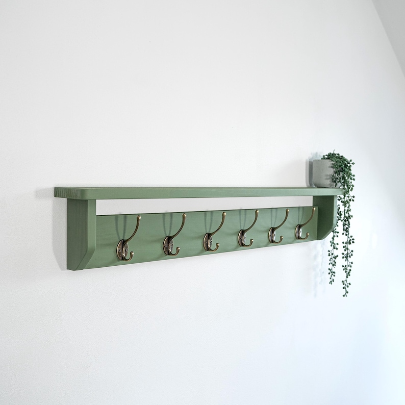 Green towel rack with brass hooks