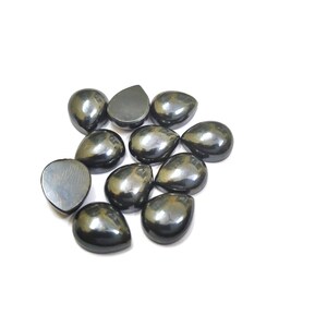 May include: A collection of teardrop-shaped, polished, dark gray hematite stones. The stones have a smooth, reflective surface and are arranged on a white background. These gemstones are ideal for jewelry making or collecting.