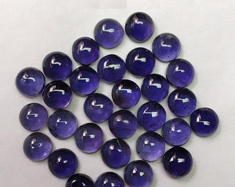May include: A collection of round, purple amethyst cabochons. The cabochons are smooth and polished, with a slight sheen.
