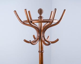 Può includere: Un appendiabiti in legno con una parte superiore circolare e numerosi ganci. L'appendiabiti è realizzato in legno marrone scuro e ha un design semplice ed elegante.