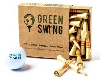 May include: A box of 20 bamboo golf tees, each 70mm long. The box is brown with the words "GREEN SWING" printed on it. The tees are natural colored with orange stripes and a green logo. The box is next to a white golf ball with the same logo.