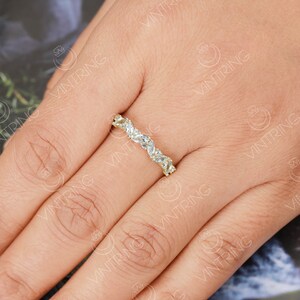 May include: A gold band ring with a row of marquise-shaped clear stones set in a pave setting.