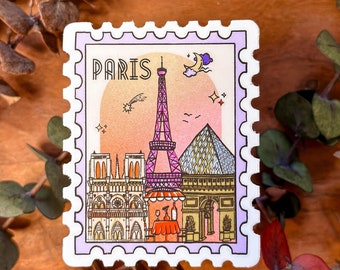 Può includere: Un adesivo bianco con un bordo viola e la parola "PARIS" in un font retrò. L'adesivo presenta una Torre Eiffel rosa, una Cattedrale di Notre Dame rosa, un Arco di Trionfo rosa e una Piramide del Louvre rosa. L'adesivo ha uno sfondo arancione chiaro con una luna crescente, una stella cadente e stelle.