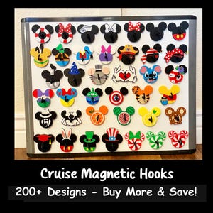 May include: A collection of colorful magnetic hooks in various designs, including Mickey Mouse and Minnie Mouse. The hooks are displayed on a white magnetic board. The text "Cruise Magnetic Hooks" and "200+ Designs - Buy More & Save!" are at the bottom.