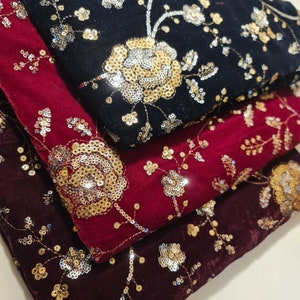 May include: Three velvet fabric squares with gold and silver sequins embroidered in floral patterns. The top square is black, the middle square is burgundy, and the bottom square is a darker burgundy.