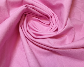 Peut inclure: Gros plan sur un tissu doux et rose à la texture lisse et uniforme. Le tissu est plié et drapé, créant un effet doux et fluide.