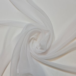 May include: White sheer fabric draped and folded in a swirl pattern. The fabric is soft and delicate, with a smooth texture.