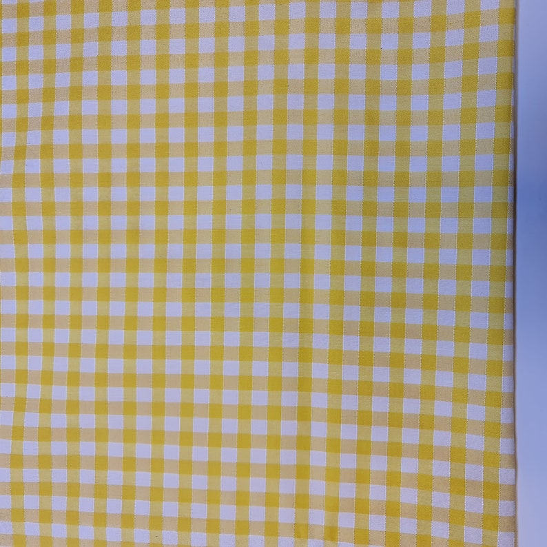 May include: Yellow and white checkered fabric with a fine weave. The fabric has a subtle sheen and is perfect for crafting projects.