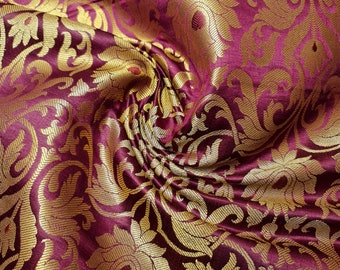 May include: Burgundy fabric with a gold brocade pattern. The fabric has a subtle sheen and a luxurious feel.