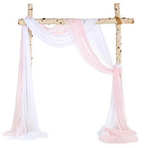 May include: White and pink sheer fabric drapes hanging from a wooden archway. The fabric is draped in a way that creates a soft and romantic look. This would be perfect for a wedding ceremony or other special event.