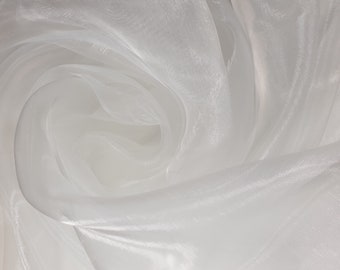 May include: White sheer fabric with a soft, flowing texture. The fabric is draped and folded, creating a swirling pattern.