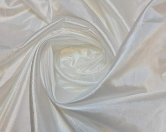 May include: White satin fabric with a smooth, silky texture. The fabric is draped and folded, creating a soft, flowing look.