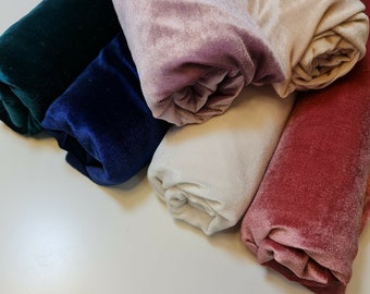 May include: Five rolls of velvet fabric in different colors: emerald green, navy blue, ivory white, dusty rose, and burgundy red.