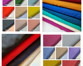 Op de afbeelding: Een verzameling stofstalen in verschillende kleuren, waaronder lavendel, teal, koraal, geel, turquoise, licht perzik, steen, zalmroze, mauve, lucht, nieuw blauw, beige, lila, olijfgroen en stoffig roze.